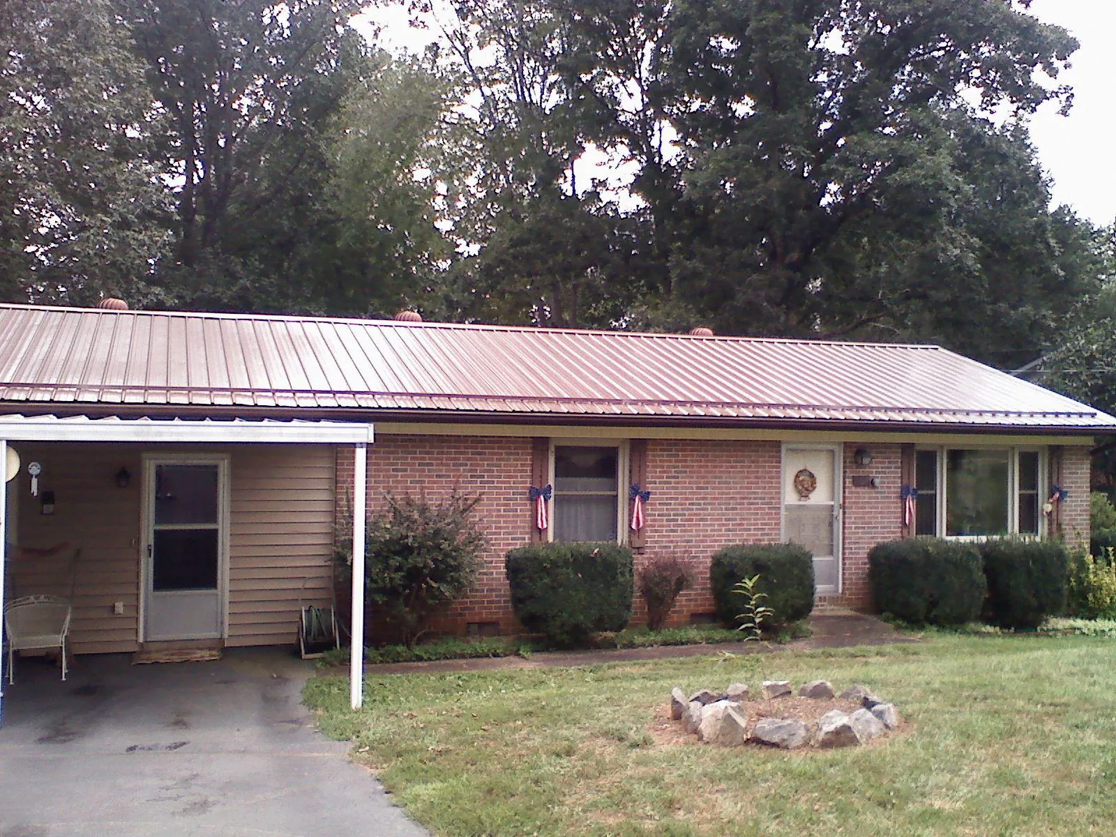 Bronze metal roof and carport on a brick ranch home — Roof Repair work by our crew in Poolesville